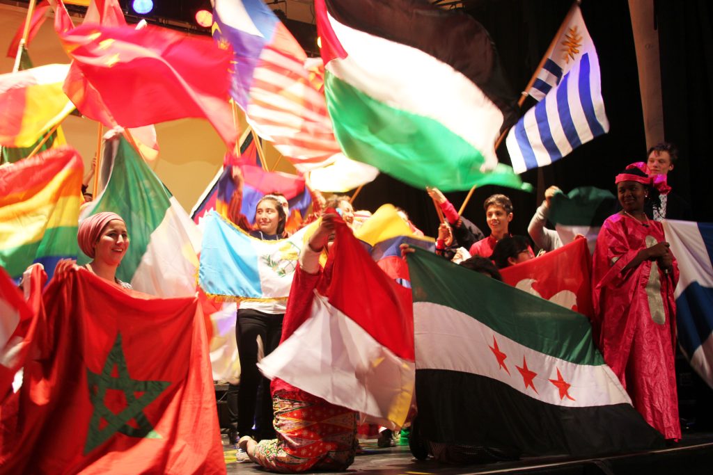 UWC students on stage with national flags